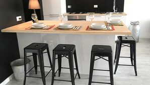 A modern kitchen with a central island, bar stools, and a dining setup. - Iseo Lake View - the window on the harbor (Iseo)