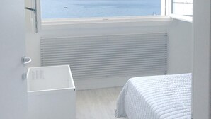 A bedroom with a large window overlooking a body of water and distant mountains. - Iseo Lake View - the window on the harbor (Iseo)