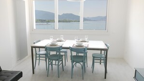 A dining area with a table set for four, a view of a lake and mountains, and a radiator on the wall. - Iseo Lake View - the window on the harbor (Iseo)