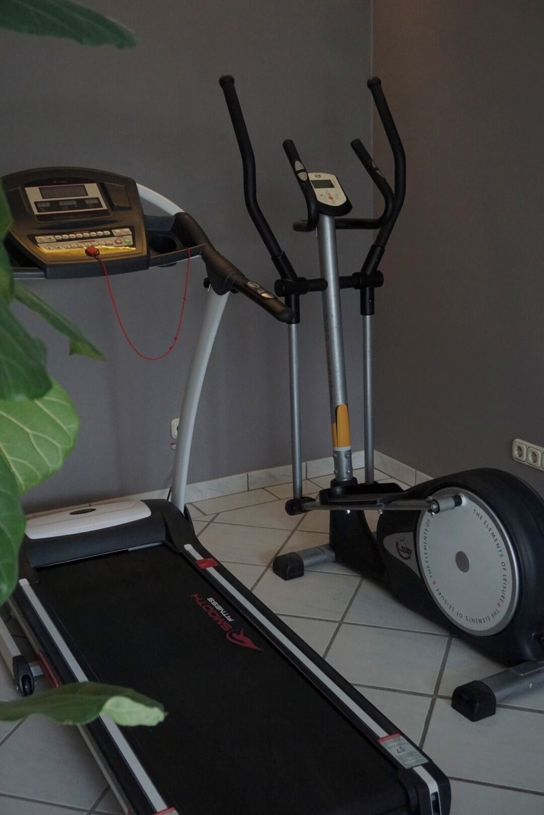 A treadmill with a digital display and a stationary bike with a digital display.