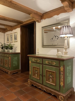 Traditional room with a wooden ceiling, tiled floor, and ornate cabinet.