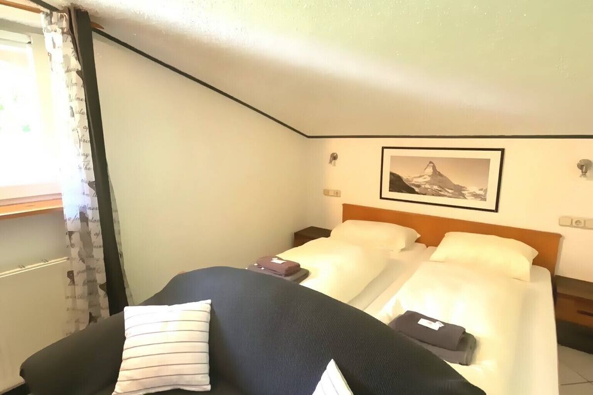 Une chambre d’hôtel avec un lit, un canapé et un tableau au mur.