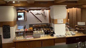 Un buffet de petit-déjeuner proposant une variété d’aliments et un coin café.
