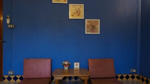 A room with two brown cushioned chairs and a small table with a vase of flowers and a card. - Long-Maa-Doo-Resort (Suan Phueng)
