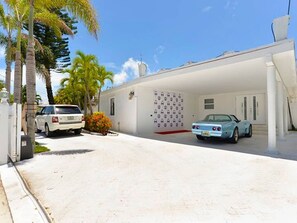 Stylish home with a modern design, featuring a covered parking area and a spacious driveway.