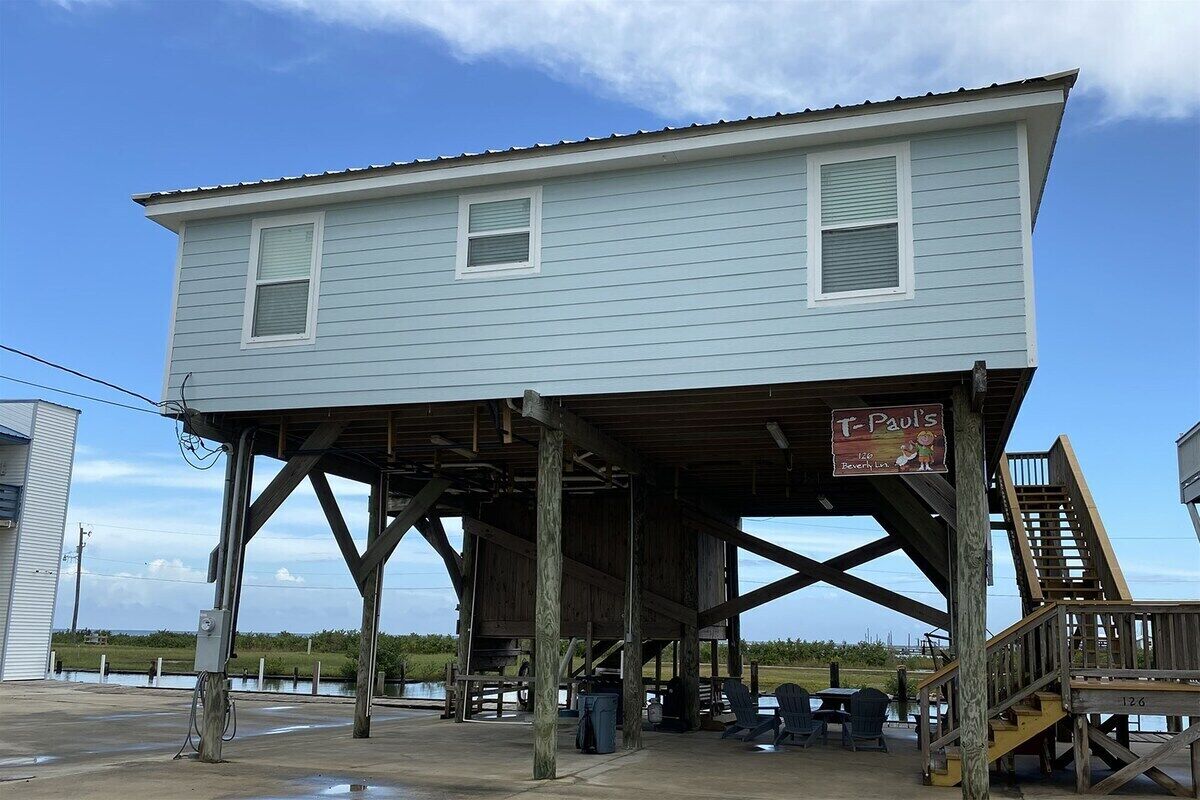 A two-story building with a covered outdoor area, a sign for 'T-Paul's', and a staircase leading to the upper level.