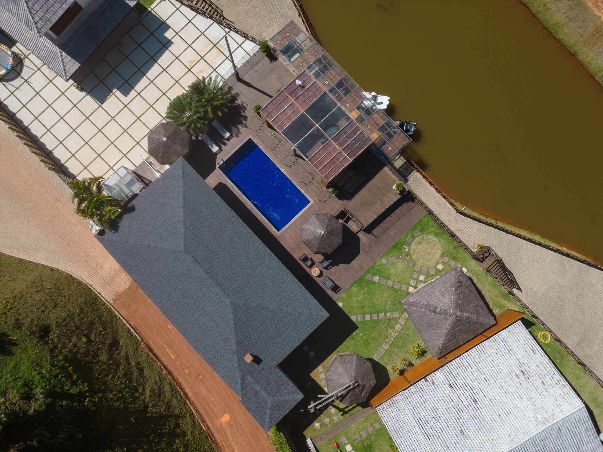 Oversigtsbillede af en ejendom med swimmingpool, udendørs møbler og et spejlbassin.