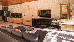 Una cucina moderna con una parete in pietra, forno integrato e un grande piano cottura nero.