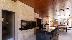 Una cucina moderna con un'isola grande, elettrodomestici integrati e una parete in pietra.
