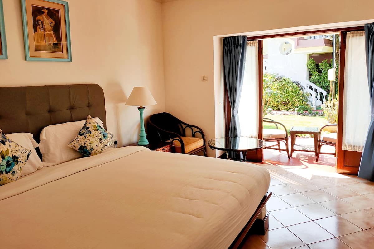 Habitación de hotel con cama, una silla, una mesa y vistas al exterior.