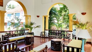 Un vestíbulo espacioso con techos altos, muebles de madera y grandes ventanales que ofrecen vistas al exterior.