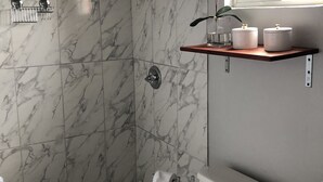 A bathroom with a shower, toilet, and sink.