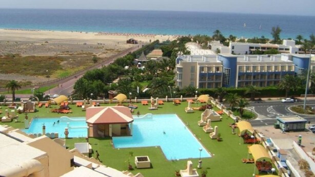 A resort with a swimming pool, beach view, and multiple buildings.