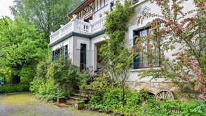 A traditional building with a stone foundation, a wooden staircase, and a large wheel. - Villa Ariane Saint-Jorioz (Saint-Jorioz)