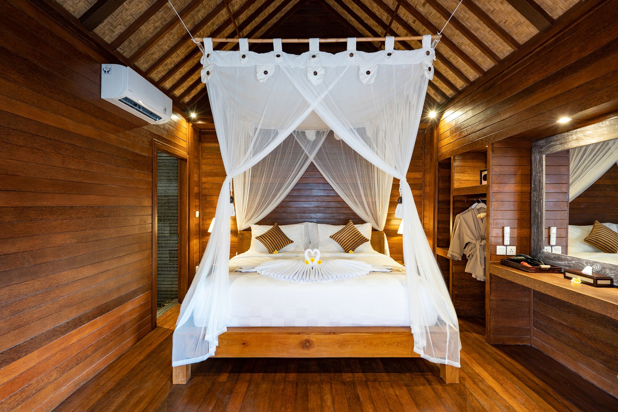 A wooden cabin-style bedroom with a four-poster canopy bed, a wooden bench, and a mirror on the wall.