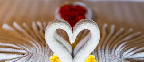A towel arranged in a heart shape with yellow flowers.