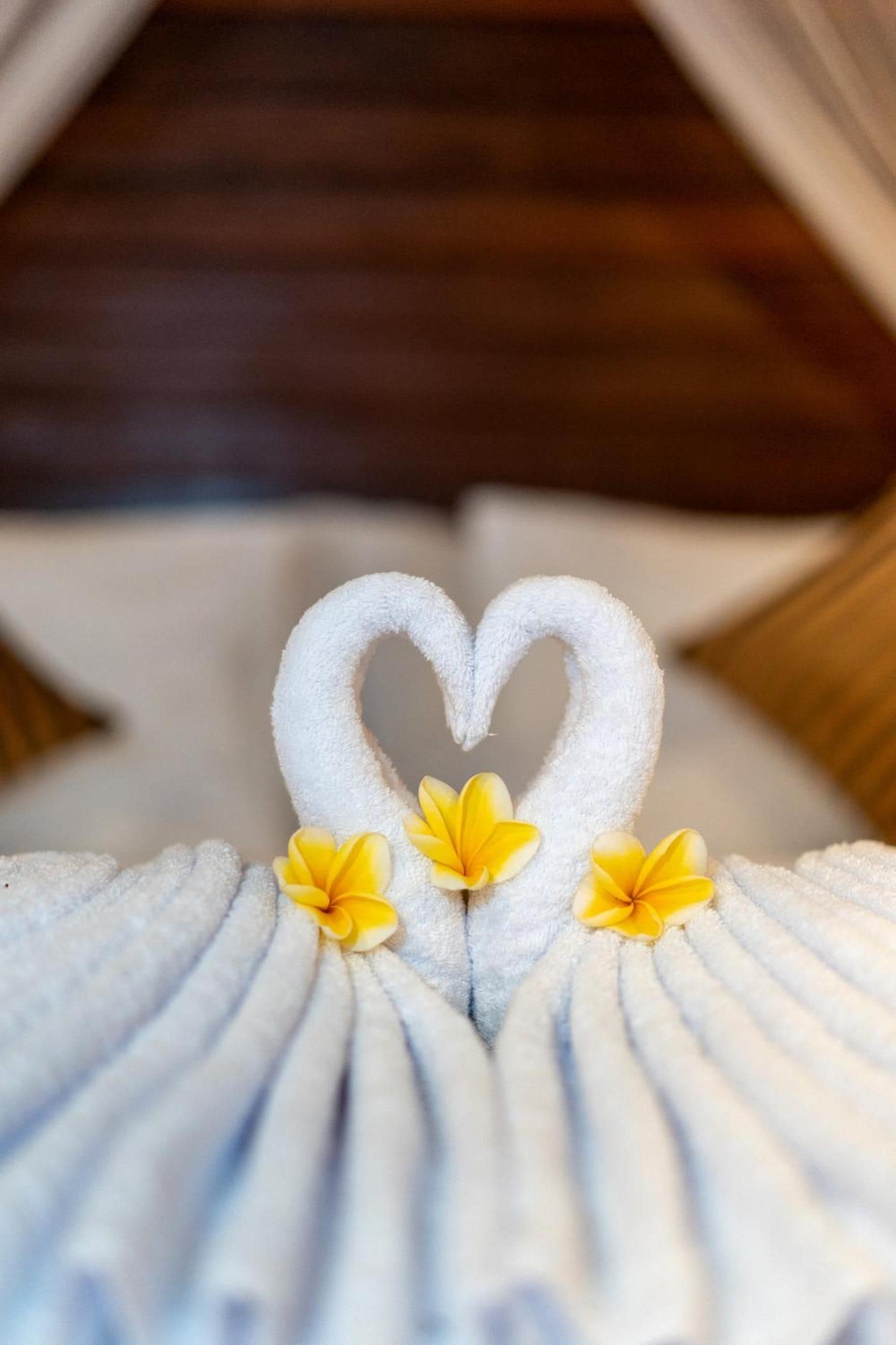 Una toalla con un diseño de corazón y tres flores amarillas.