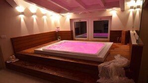 Un dormitorio con cama de madera, bañera de hidromasaje y ventana con vistas.