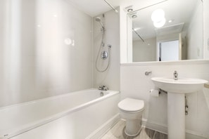 Bathtub, hair dryer, towels, shampoo