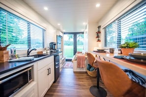 Una cocina moderna con comedor, ventanas amplias y vistas al exterior.