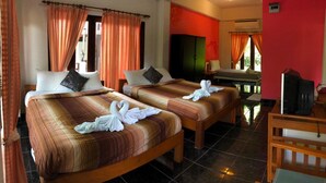 Ein Hotelzimmer mit zwei Betten, einem Fernseher und einem kleinen Tisch.