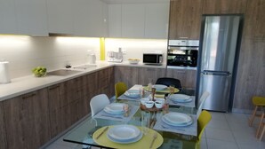 Eine moderne Küche mit einem Glastisch, Holzschränken und Edelstahlgeräten.