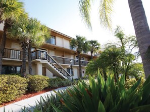 Stunning hotel building with a central staircase and beautifully landscaped grounds.