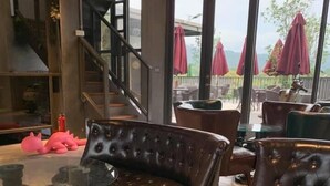 Ein Restaurantinnenraum mit Ledersofas, einem Glastisch und einer Treppe.