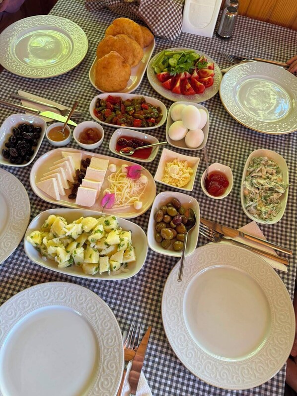 A table set with various dishes, including a salad, eggs, and a fruit bowl.