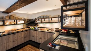Una cocina con armarios de madera, una vitrina de vidrio y diversos alimentos.