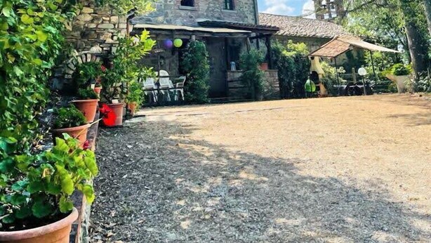 A rustic stone building with a stone staircase leading to a wooden door.