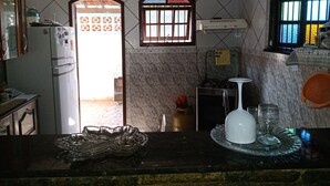 Une cuisine équipée d’un réfrigérateur, d’une cuisinière et d’une fenêtre ornée de vitraux.