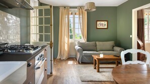 A compact kitchen with a gas stove, a built-in oven, and a window with curtains. - La Petite Affolante, charming residence in Samois Sur Seine (Samois Sur Seine)