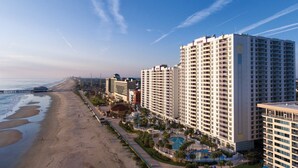 Ein Küstenhotel mit mehreren Hochhäusern, einem Strand und einer Pier.