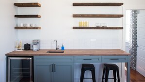 Eine Küche mit Holzböden, einer Kaffeemaschine und einem Waschbecken.