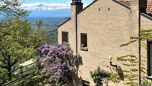 A brick building with a view of snow-capped mountains in the background. - The paradise of relaxation, villa in the Langhe with panoramic views (Lequio Berria)