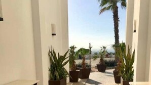 A corridor with a stone floor, potted plants, and white walls. - Master Penthouse lujo y comodidad (La Paz)