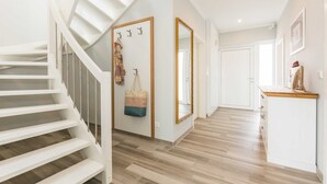 A staircase leading to a landing with a coat rack and a mirror.