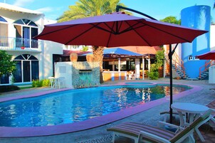 Una piscina al aire libre, sillones reclinables de piscina