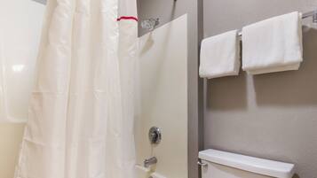 A bathroom with a shower curtain, a toilet, and a towel rack.