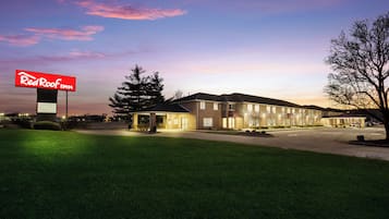 A Red Roof Inn with a brick exterior, multiple windows, and a well-lit parking area.