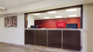 A reception desk with a red sign indicating free Wi-Fi in all rooms. - Red Roof Inn Lawrenceburg (Lawrenceburg)