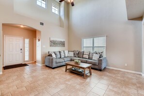 Relax in this stylish living room with a large sofa, coffee table, and abstract art.