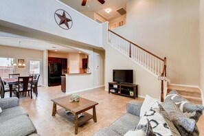 Relax in this stylish living area with a high ceiling, modern kitchen, and comfortable seating.