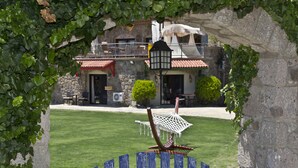 A stone building with a red-tiled roof, a white canopy, and a seating area with chairs and tables. - Palmiye Tepesi (Bodrum)