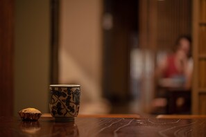 Une table en bois avec une tasse en céramique et un muffin.