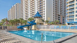 A swimming pool with a water slide, surrounded by high-rise residential buildings. - Two Bedroom Luxury Condo, Daytona Beach (1732048) (Daytona Beach)