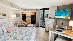 A hotel room with a bed, a dining area, a kitchen, and a balcony with a TV displaying a beach scene. - 2 BALCONIES/DIRECT OCEANFRONT/PET FRIENDLY/CORNER UNIT/ BEST VIEW/RESTAURANT (Myrtle Beach)
