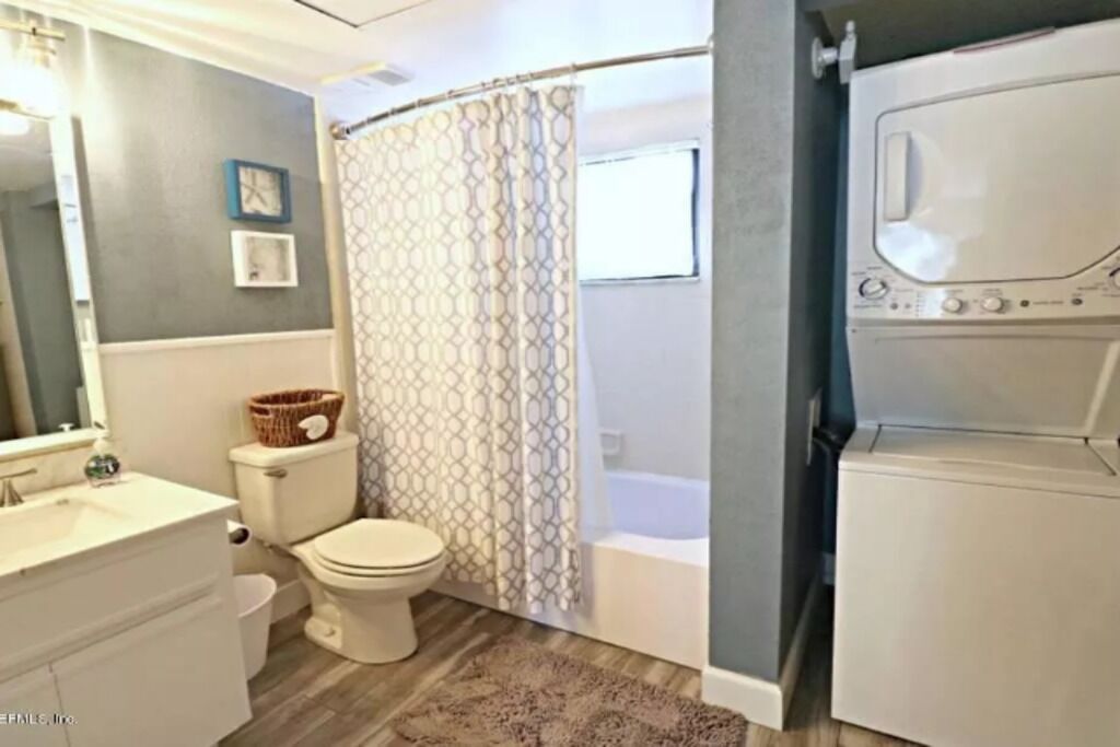 Un baño con inodoro, lavamanos y lavadora.