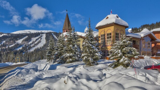 A snow-covered mountain landscape with a church and a chalet-style building. - Perfectly Located beautiful 4 bedroom townhouse (Sun Peaks)
